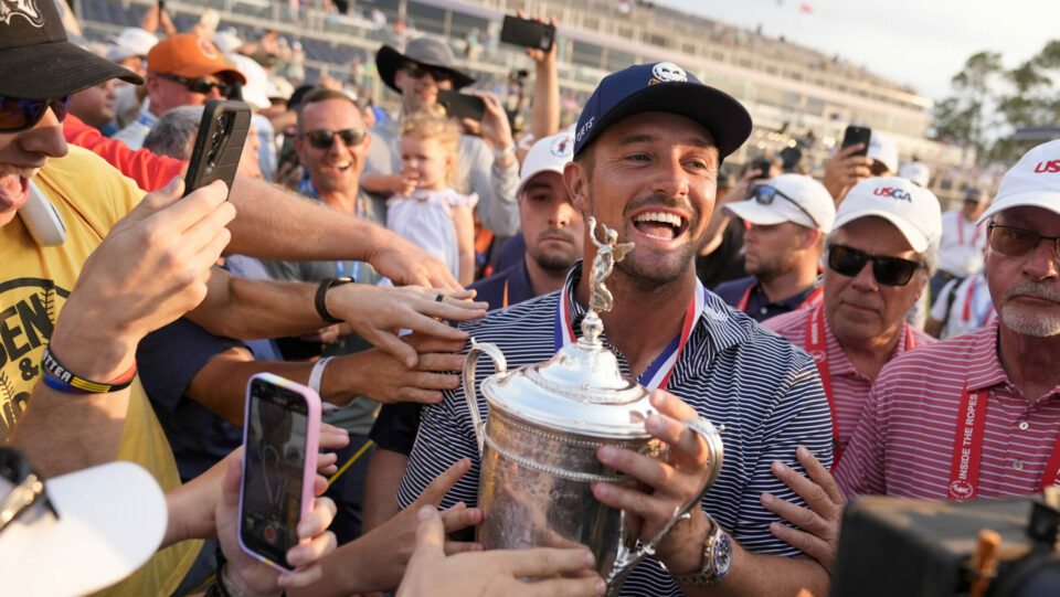 Bryson DeChambeau is surrounded by fans as he holds the US Open trophy