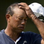 Tiger Woods wipes his face on a hot day two of the US Open