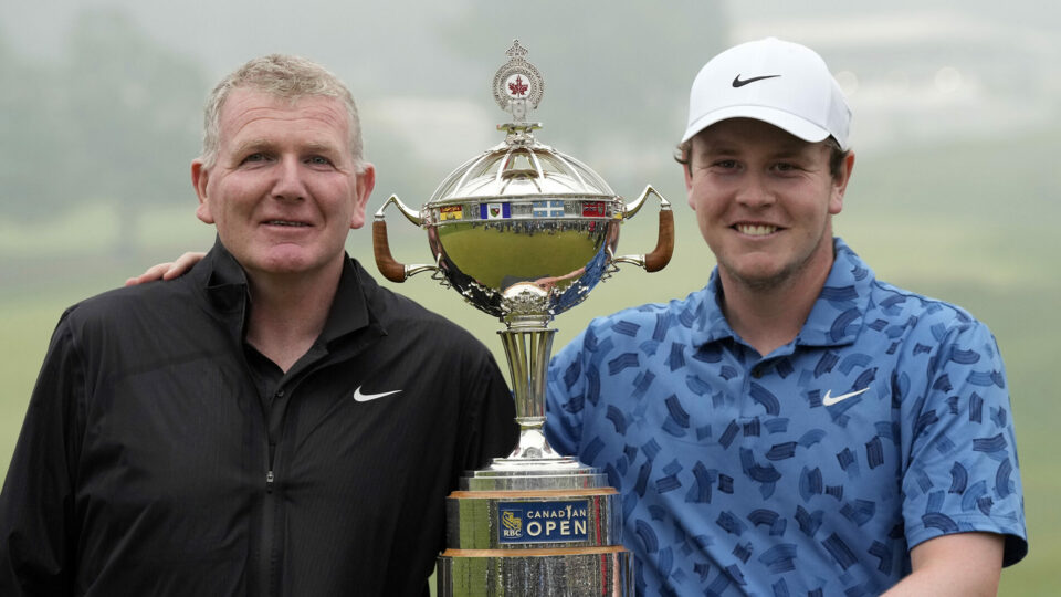 Scotland’s Robert MacIntyre (right) and his father and caddie Dougie pose for photos with the RBC Canadian Open trophy