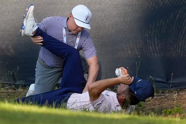 Bryson DeChambeau gets treatment on the 11th hole during the third round of the US Open