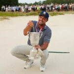 Bryson DeChambeau holds the US Open trophy in the bunker from which he made the winning par at the US Open at Pinehurst