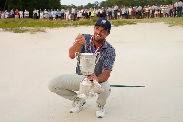 Bryson DeChambeau holds the US Open trophy in the bunker from which he made the winning par at the US Open at Pinehurst
