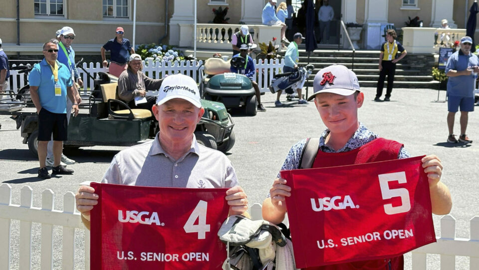 Frank Bensel and son Hagen hold pin flags at the US Senior Open