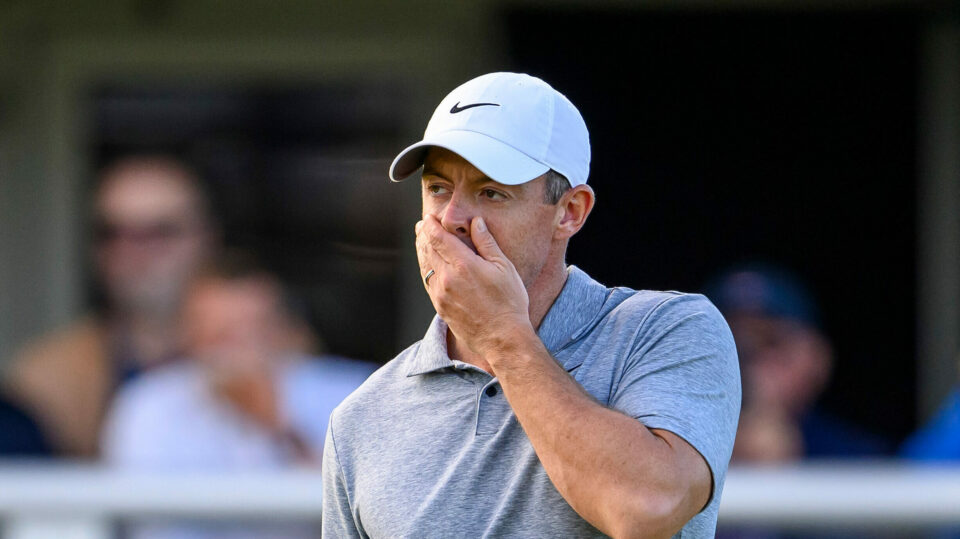 Rory McIlroy covers his mouth with his hand