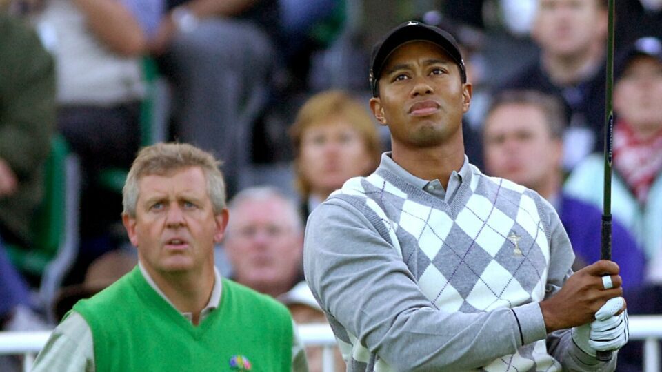 Colin Montgomerie watches Tiger Woods hit a shot