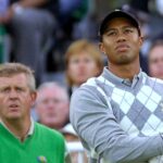 Colin Montgomerie watches Tiger Woods hit a shot