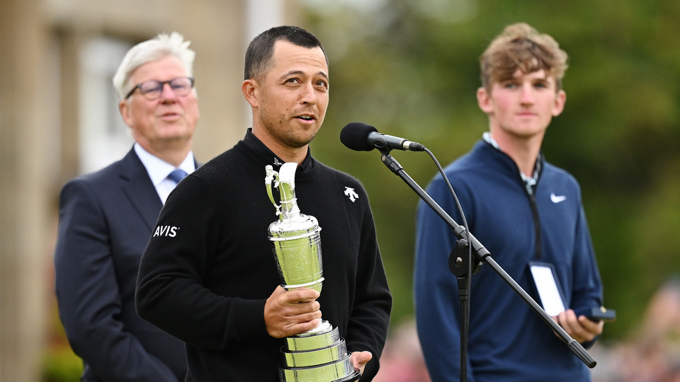 The Champion golf of the year speaks on the 18th green holding the Claret Jug