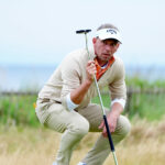 Marcel Siem crouches down leaning on his putter