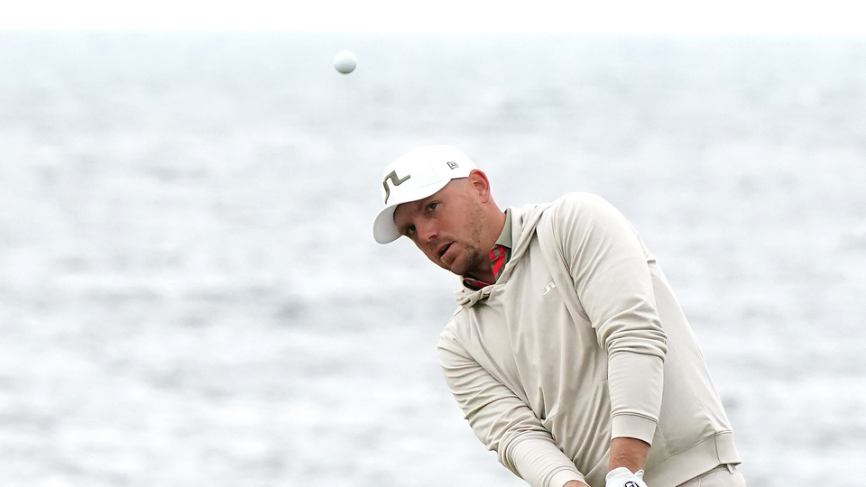 England’s Matt Wallace chips towards the green with the sea in the background